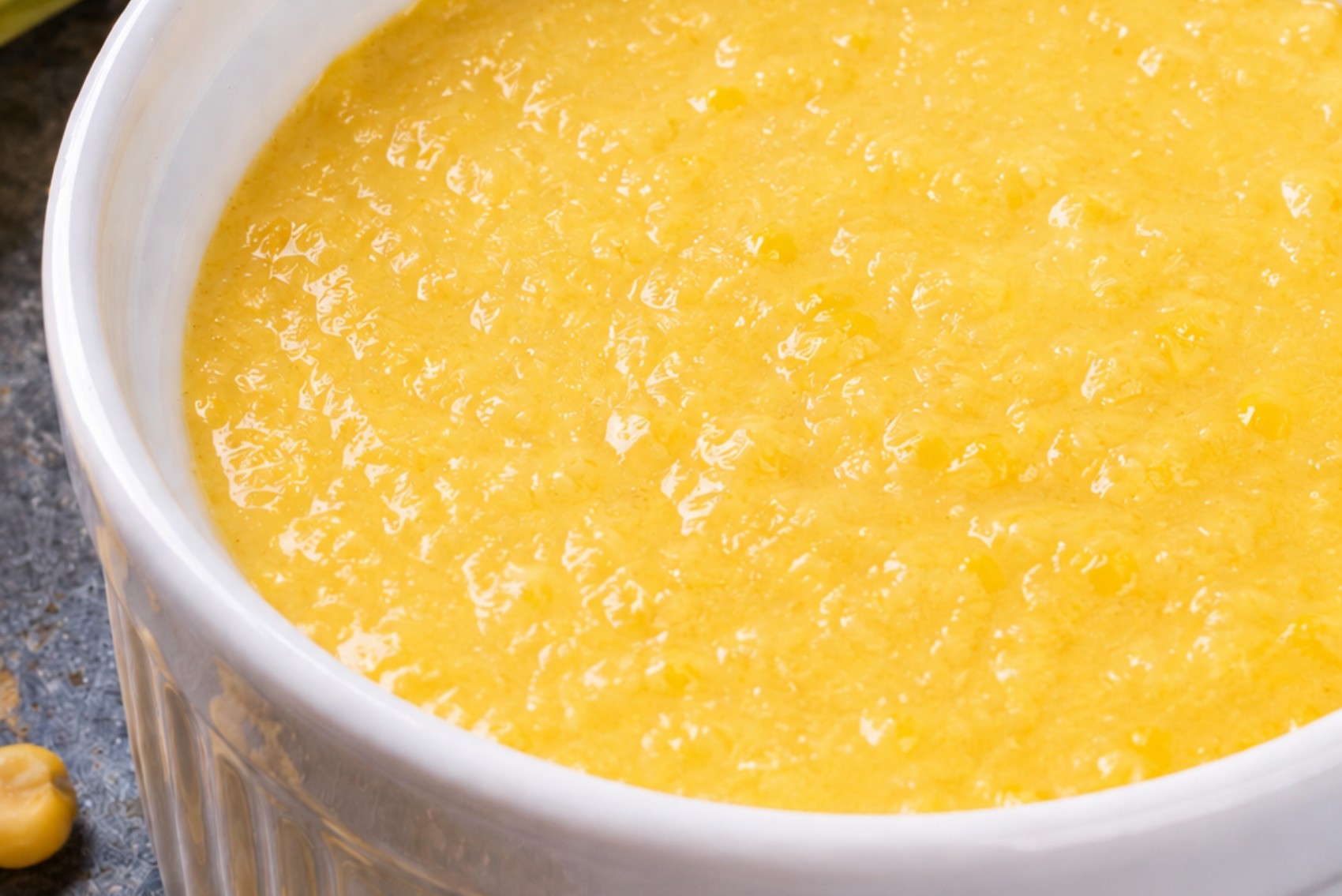 curau de milho fresco sem açúcar: creme amarelo cremoso em tigela branca com milho orgânico