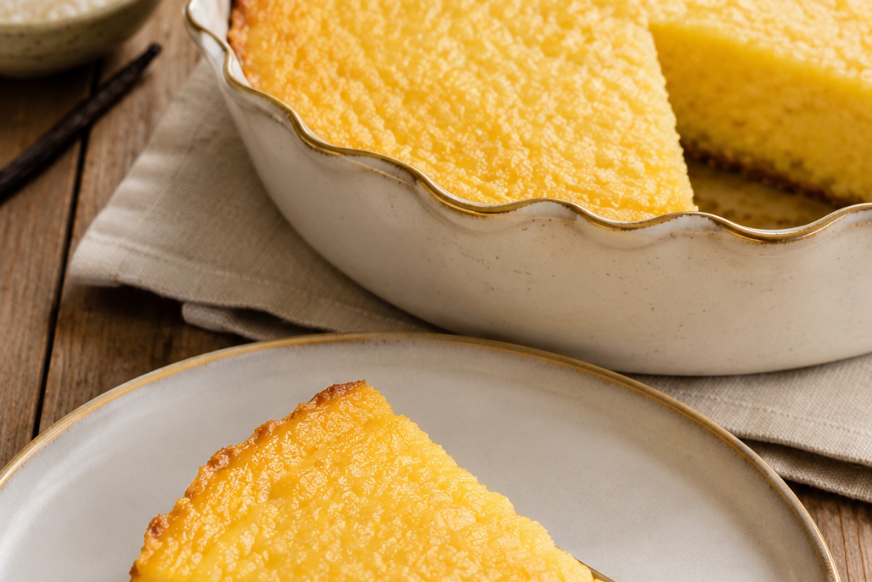 pamonha de forno com coco sem açúcar: fatia dourada em prato rústico sobre mesa de madeira